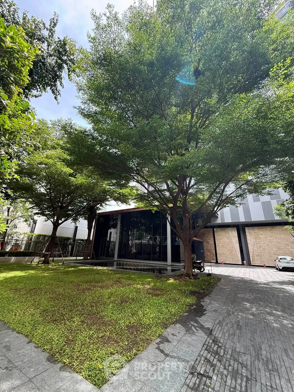 Modern building exterior with lush green garden and paved walkway