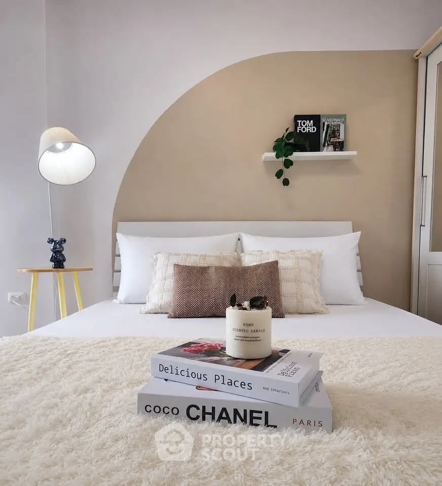 Stylish bedroom with modern decor and cozy ambiance, featuring designer books and elegant lighting.