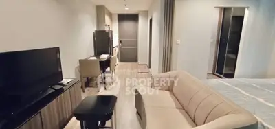 Modern open-plan living room with cozy sofa and dining area in stylish apartment.
