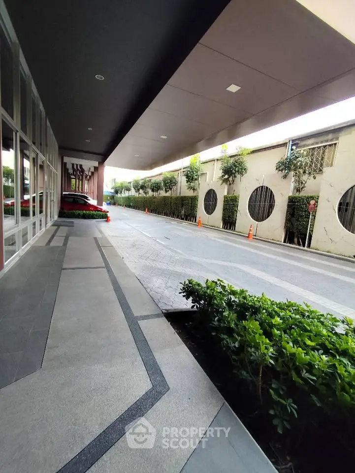 Modern building entrance with sleek design and lush greenery