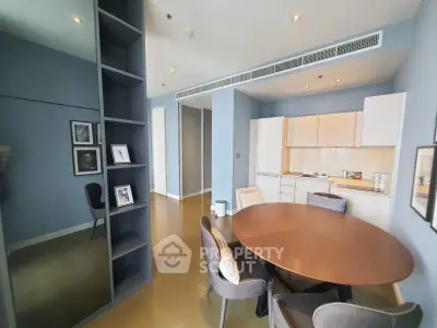 Modern dining area with round table and open kitchen in stylish apartment