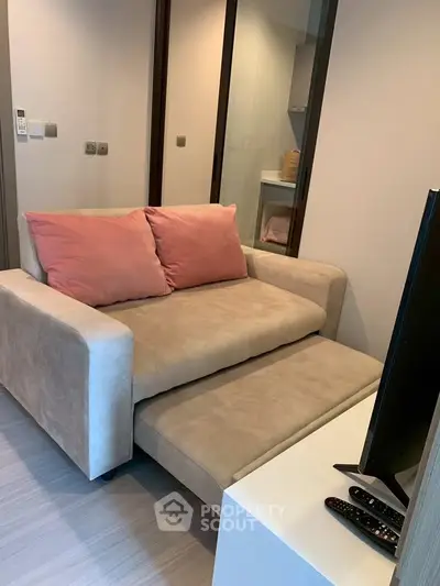 Cozy living room with modern sofa and TV setup, perfect for relaxation.