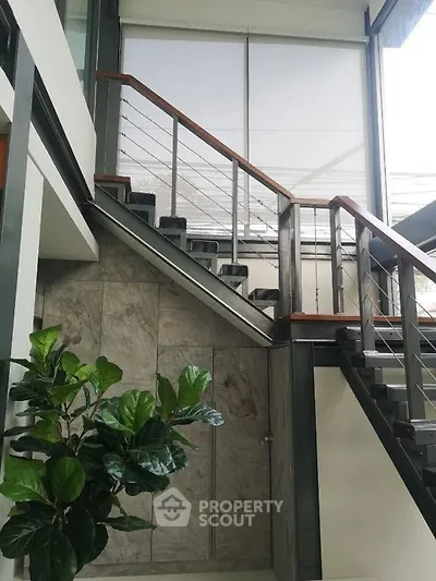 Modern staircase with sleek design and large window in contemporary home