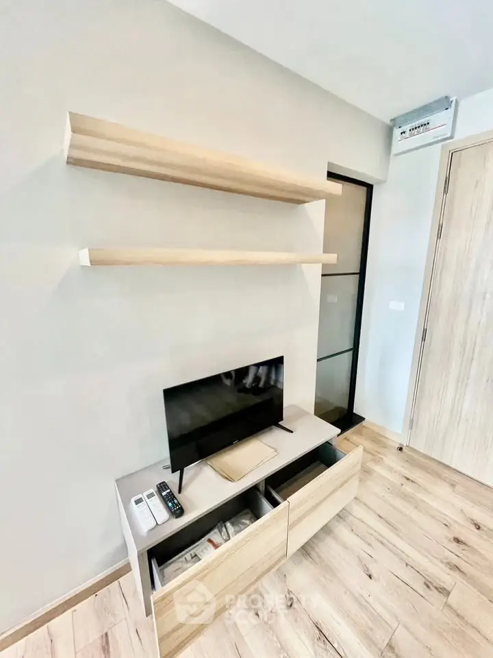 Modern living room with sleek wooden shelves and compact TV unit, perfect for minimalist design enthusiasts.