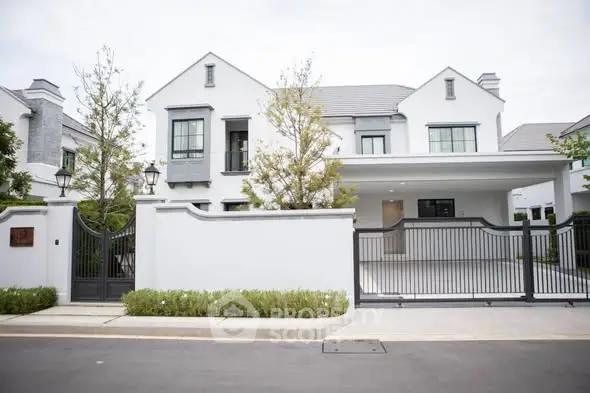 Elegant modern white house with gated entrance and spacious driveway in a serene neighborhood.