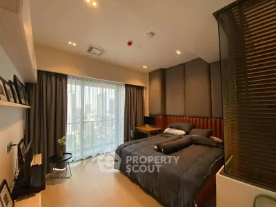 Luxurious modern bedroom with large windows and elegant decor in a high-rise apartment.