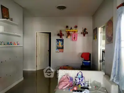 Cozy living room with wall decor and open doorway leading to kitchen area.
