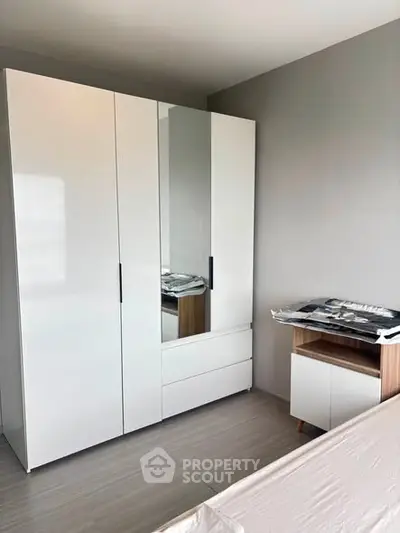Modern bedroom with sleek white wardrobe and minimalist design