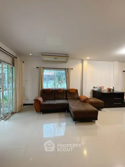 Spacious living room with modern sofa and large window view.