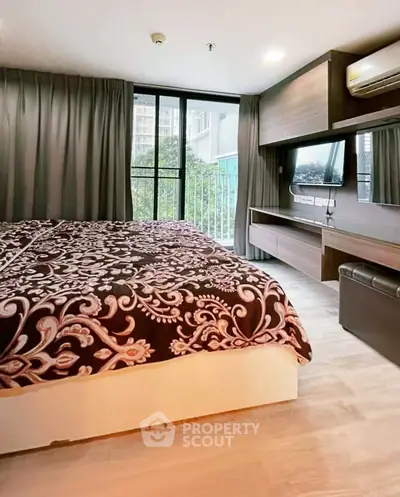 Modern bedroom with large window and stylish decor in urban apartment.