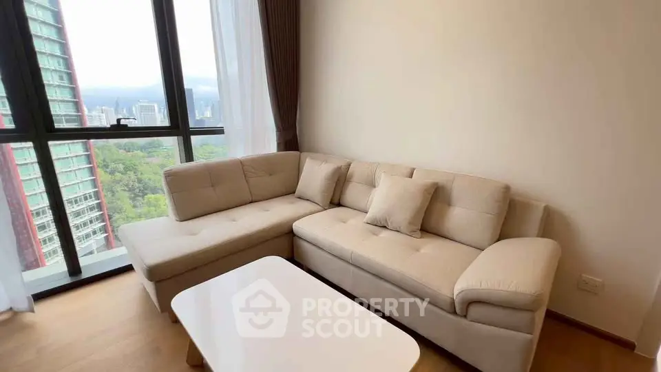 Spacious living room with modern sofa and stunning city view from large windows.