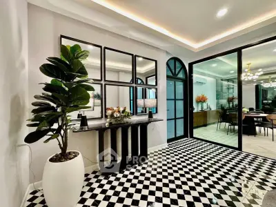 Elegant modern interior with checkered floor and stylish decor, featuring a large mirror and indoor plant.