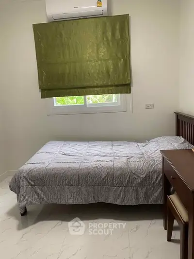 Cozy bedroom with single bed and green curtain, perfect for a peaceful retreat.