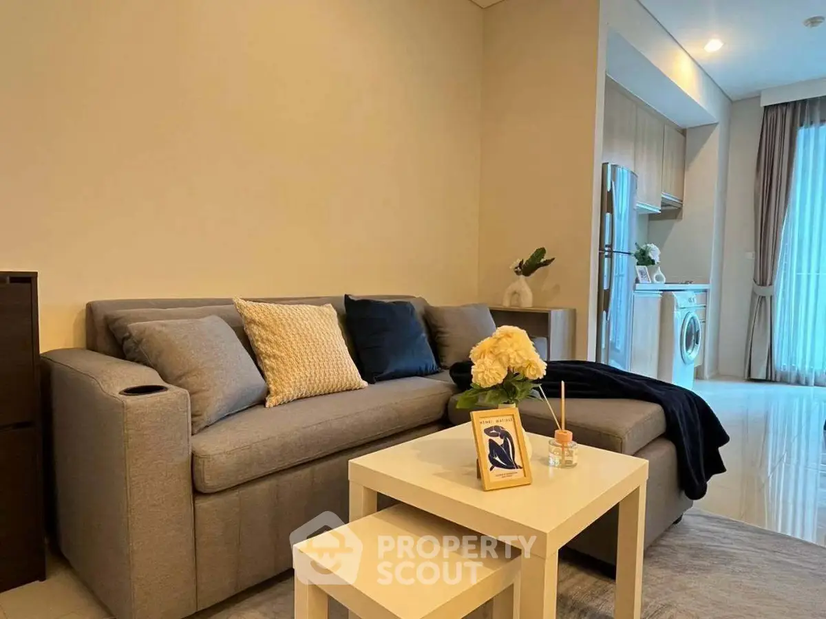 Modern living room with cozy sofa and stylish kitchen in open layout apartment.