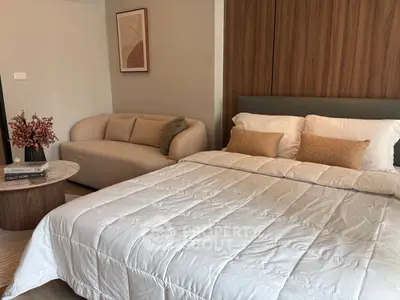 Modern bedroom with cozy sofa and stylish decor in a contemporary apartment.
