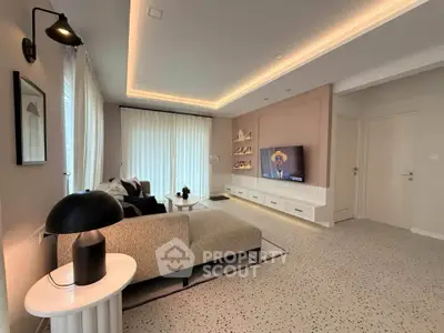 Modern living room with stylish decor and ambient lighting, featuring a cozy sofa and wall-mounted TV.