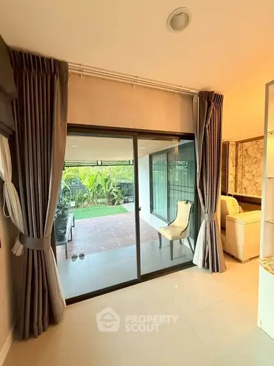 Elegant living room with sliding glass doors leading to a lush garden view.