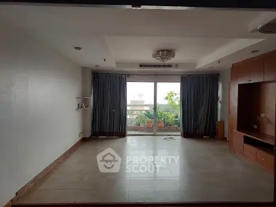 Spacious living room with large windows and built-in shelving, perfect for modern living.
