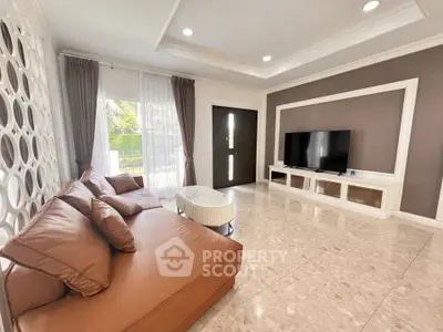 Luxurious living room with elegant decor and large TV, perfect for relaxation and entertainment.