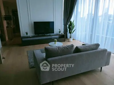 Modern living room with sleek furniture and large windows offering natural light.