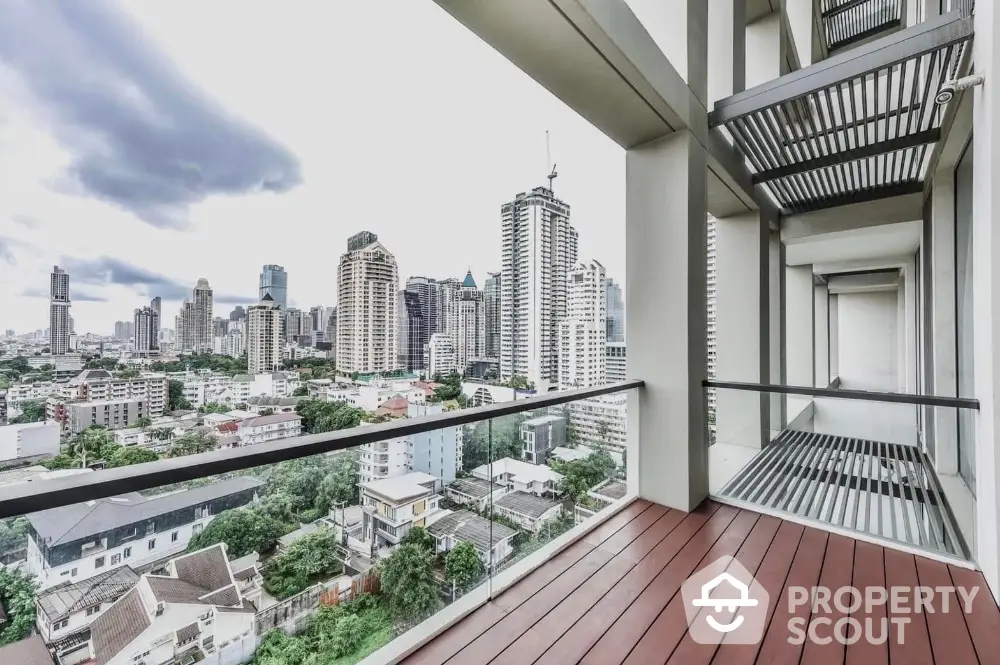 Stunning city view from modern apartment balcony with sleek glass railing.