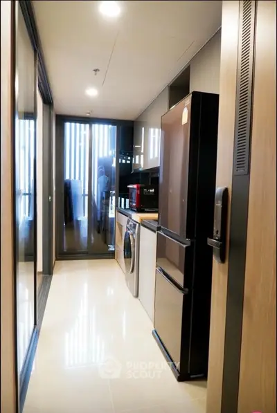 Modern kitchen with sleek appliances and ample storage in a stylish apartment.