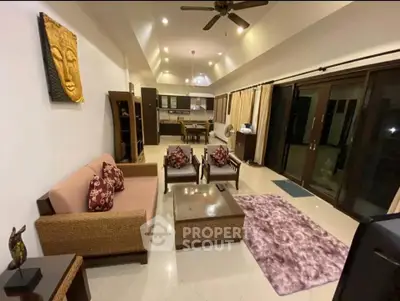 Spacious living room with modern decor and open layout leading to a stylish kitchen.