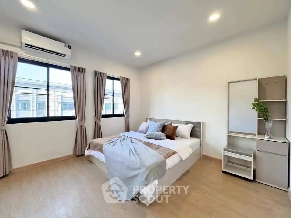 Spacious modern bedroom with large windows and stylish decor in a contemporary home.