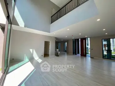 Spacious modern living room with high ceilings and large windows offering abundant natural light.