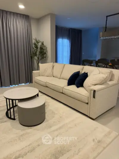 Elegant living room with modern sofa and stylish coffee tables, perfect for relaxation and entertaining.