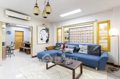 Stylish living room with blue sofa and modern decor in a bright, airy space.