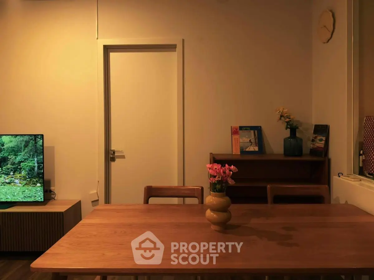 Cozy dining area with wooden table, chairs, and decorative elements in a modern apartment.
