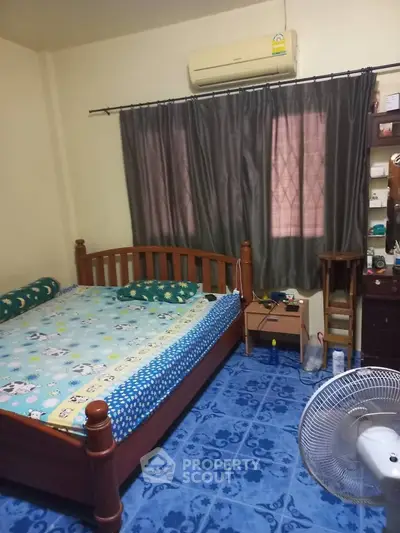 Cozy bedroom with wooden bed frame, air conditioning, and blue tiled flooring.