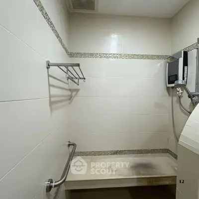 Compact bathroom with shower and wall-mounted water heater