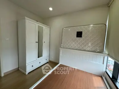 Modern bedroom with white wardrobe and large window offering natural light