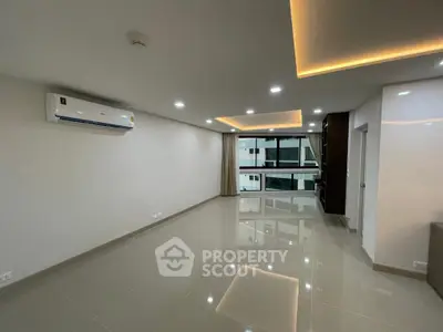 Spacious modern living room with sleek lighting and large windows