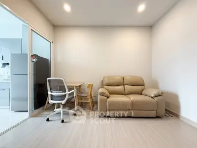 Modern living room with beige sofa and glass partitioned kitchen