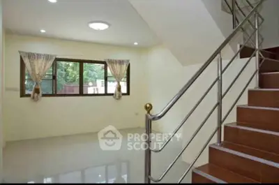Spacious interior with modern staircase and large window, perfect for natural light.