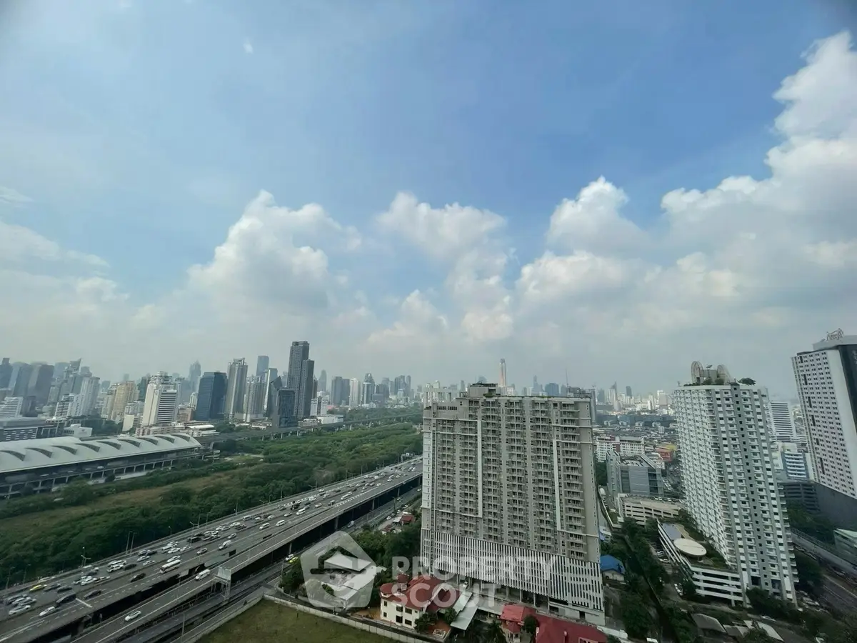 Stunning cityscape view from high-rise apartment with lush greenery and urban skyline.