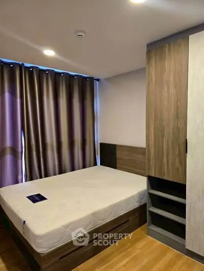 Modern bedroom with wooden flooring and stylish wardrobe in a cozy apartment.