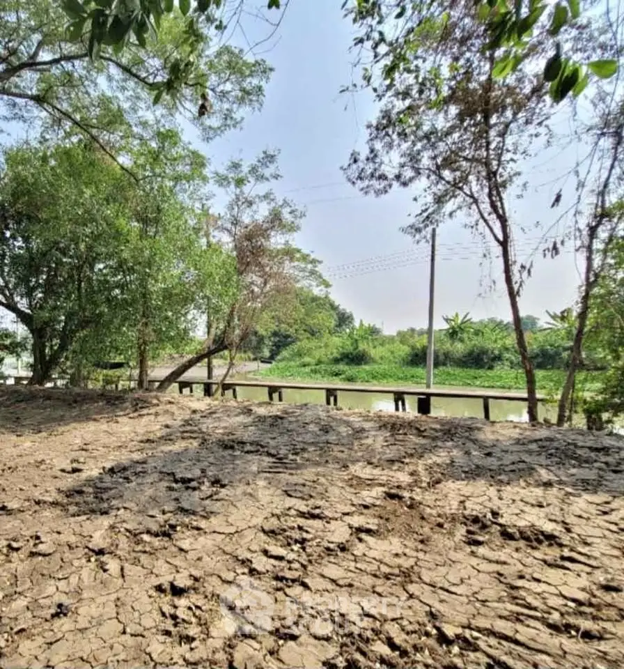Scenic riverside land with lush greenery and serene water view, perfect for development or investment.