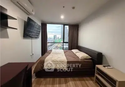 Modern bedroom with city view, featuring a cozy bed, wall-mounted TV, and air conditioning.