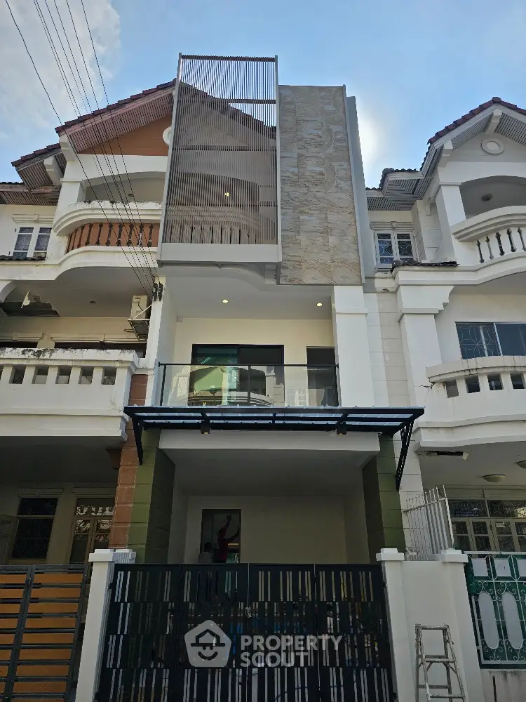 Modern three-story townhouse with unique facade design and spacious balcony