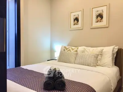 Cozy bedroom with elegant decor and plush bedding in modern apartment.