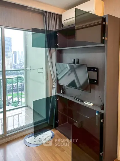 Modern living room with balcony view and wall-mounted TV in a high-rise apartment.