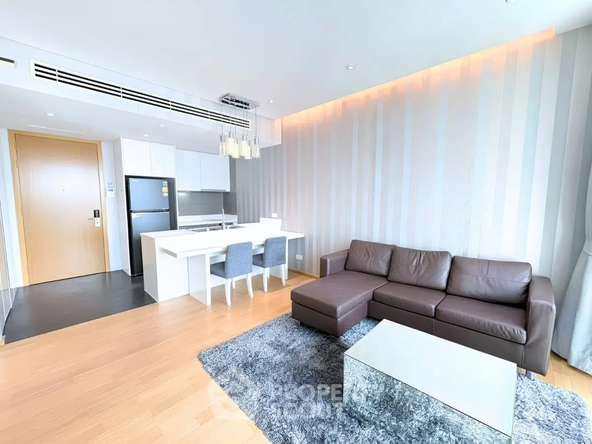 Modern living room with sleek furniture and open kitchen layout in a stylish apartment.