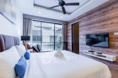 Modern bedroom with stylish decor and large window offering natural light.