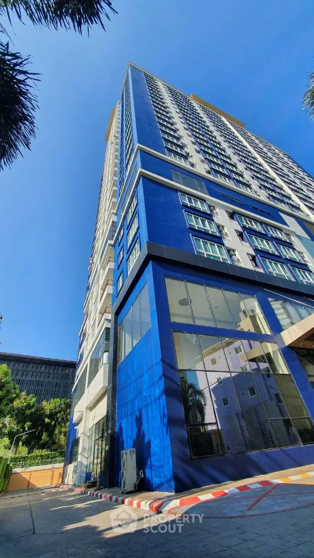 Stunning modern high-rise building with sleek blue facade and expansive glass windows.