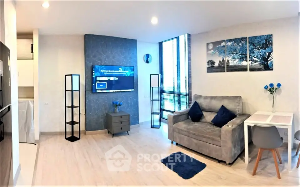 Modern living room with stylish decor, featuring a cozy sofa, wall-mounted TV, and elegant lighting.