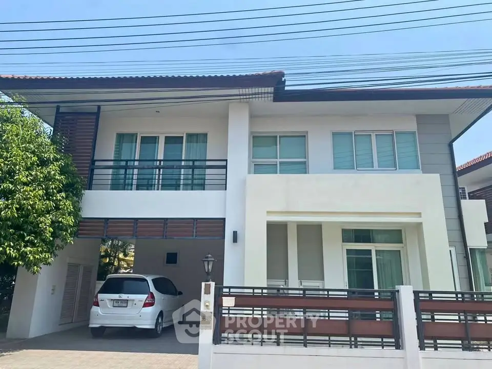 Modern two-story house with spacious driveway and sleek architectural design.